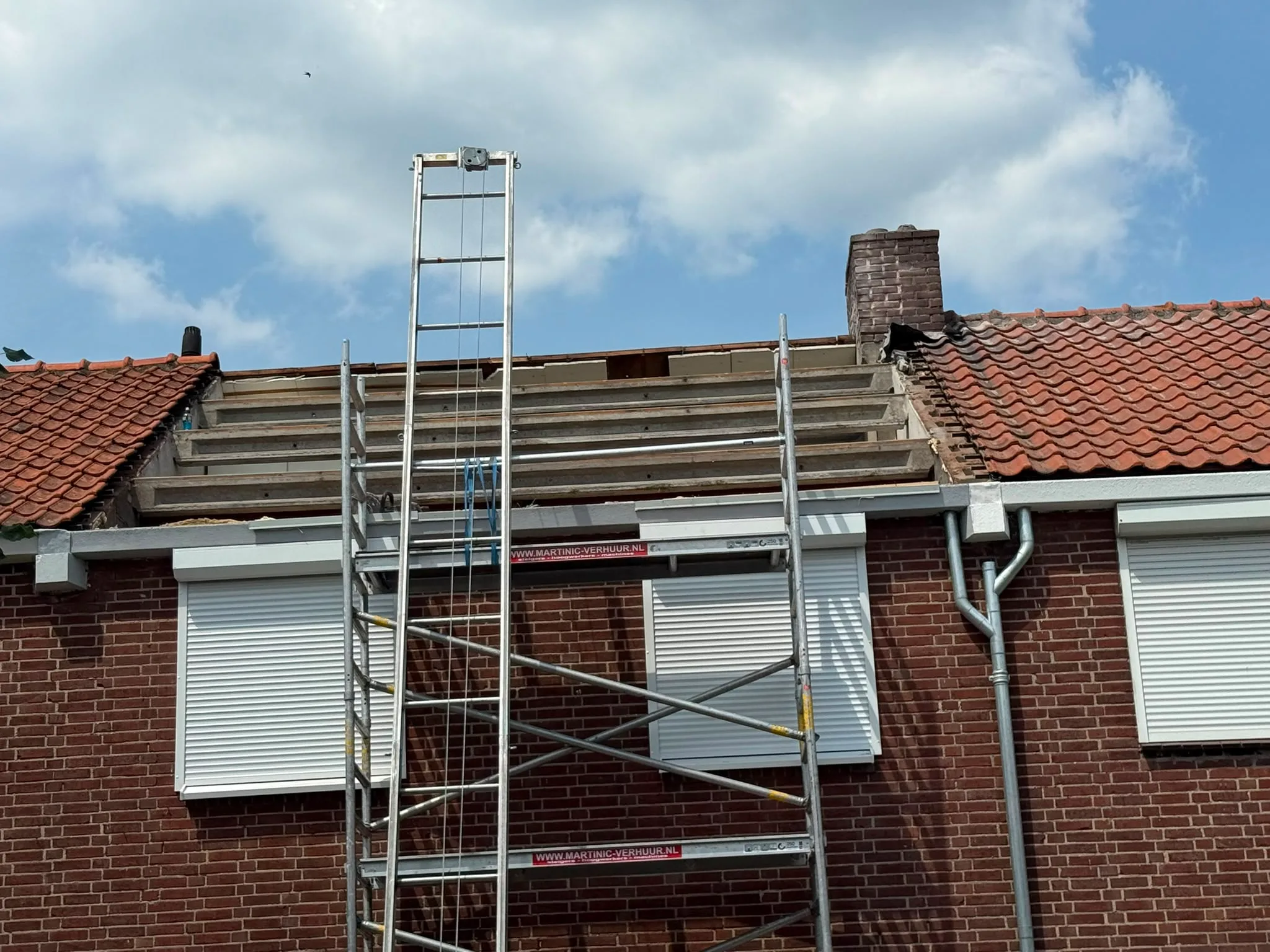 Dakrenovatie met steigering op bakstenen woning