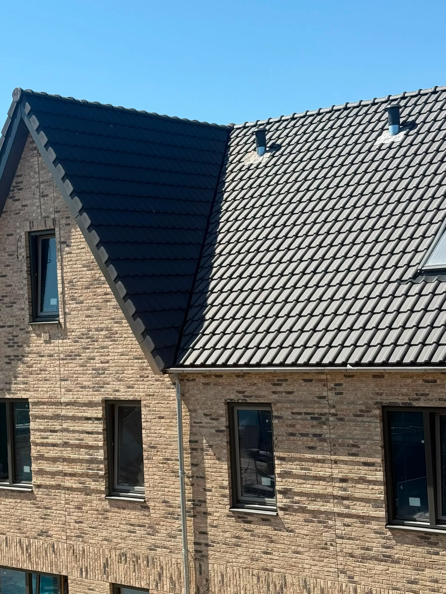 Moderne woning met zwart-wit dakpannen baksteengevel